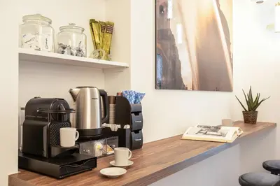 a coffee machine sitting on a wooden counter with cups at Pantheon Suites Rome 1 in Rome