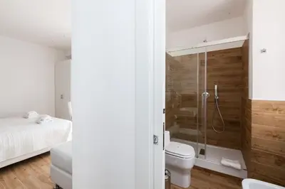 a bathroom with a shower and a toilet and a bed at Casa 901 - The Italian Stay Collection in Rome