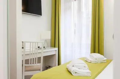 a room with a bed with yellow sheets and a chair at Casa 901 - The Italian Stay Collection in Rome