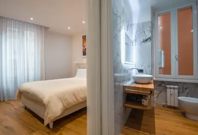 a bedroom with a bed and a sink and a mirror at AP Royal suite guesthouse in Rome