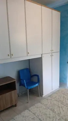 a blue chair in a room with white cabinets at B&B trastevere 2 in Rome