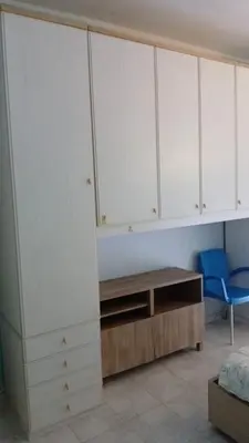 a bedroom with white cabinets and a blue chair at B&B trastevere 2 in Rome