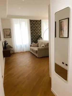 a living room with a couch and wooden floors at LovingRome Colosseum in Rome