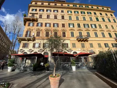a building with a potted tree in front of it at LovingRome Colosseum in Rome