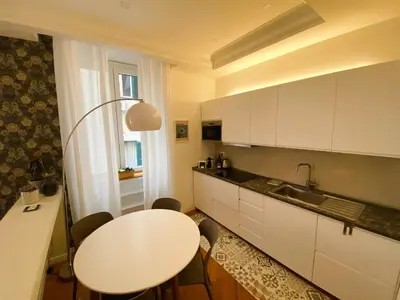 a kitchen with a white table and a white counter top at LovingRome Colosseum in Rome