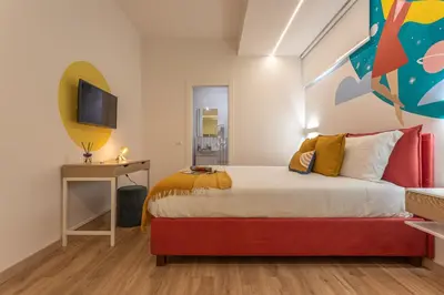a bedroom with a bed and a tv on a wall at Le Muse Suites in Rome