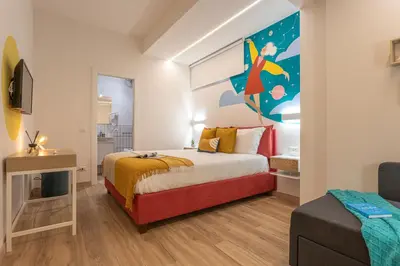 a bedroom with a bed with a painting on the wall at Le Muse Suites in Rome