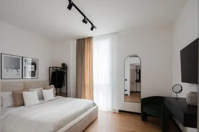 a white bedroom with a large bed and a mirror at San Lorenzo Labicana Luxury Apartment in Rome