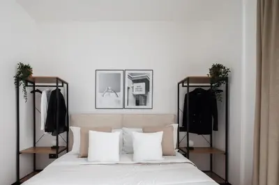 a bedroom with a bed with two racks of clothes at San Lorenzo Labicana Luxury Apartment in Rome