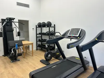 a room with a gym with a treadmill and weights at San Lorenzo Labicana Luxury Apartment in Rome