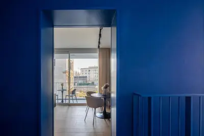 a room with a blue wall and a table with a chair at San Lorenzo Labicana Luxury Apartment in Rome