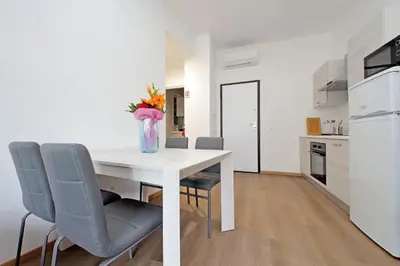 a white dining room table with chairs and a vase of flowers at Trastevere 3 apartments by Flatinrome in Rome