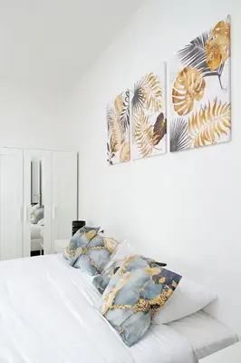 a bedroom with a white bed with two paintings on the wall at Trastevere 3 apartments by Flatinrome in Rome
