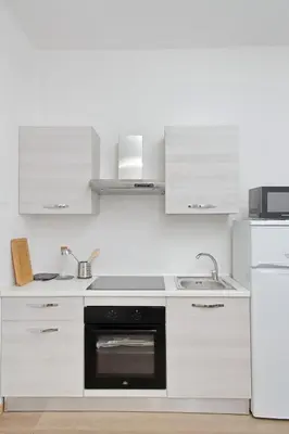 a kitchen with white cabinets and a black oven at Trastevere 3 apartments by Flatinrome in Rome