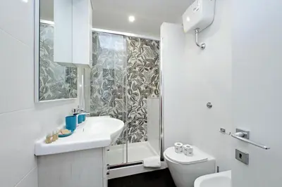 a white bathroom with a sink and a shower at Trastevere 3 apartments by Flatinrome in Rome