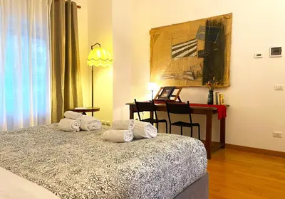 a bedroom with a bed and a desk and a table at Trastevere Advenida in Rome
