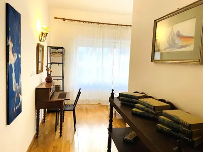 a room with a desk and a table with stacks of books at Trastevere Advenida in Rome