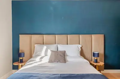 a bedroom with a large bed with a blue wall at Elegant Home San Pietro vicino alla Metro in Rome