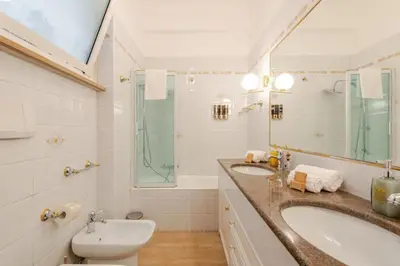 a bathroom with two sinks and a tub and a mirror at Elegant Home San Pietro vicino alla Metro in Rome