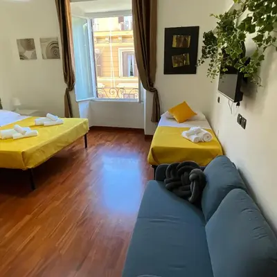 a living room with two beds and a blue couch at Maria House Saint Peter in Rome