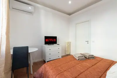 a bedroom with a bed and a desk with a tv at Casa Romana Vaticano-Metro in Rome