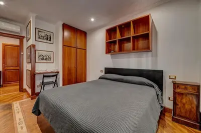 a bedroom with a bed and a desk in it at Vatican Luxury Suite Bragadin in Rome
