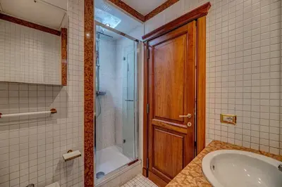 a bathroom with a tub and a shower and a shower backdoor at Vatican Luxury Suite Bragadin in Rome