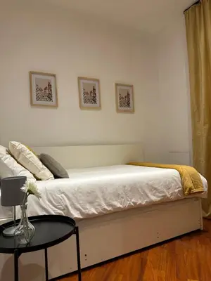 a white bedroom with a bed and a table at Balduina 225 in Rome