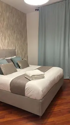 a bedroom with a large bed with white sheets at Balduina 225 in Rome
