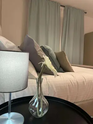 a vase with a flower on a table next to a bed at Balduina 225 in Rome
