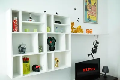 a white book shelf in a room with a tv at FLOUR SUITE - Rome Apartment in Rome