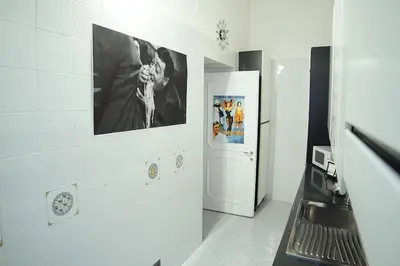a kitchen with a picture of a man in a suit on the wall at FLOUR SUITE - Rome Apartment in Rome