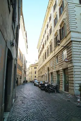 a cobblestone street with motorcycles parked next to buildings at FLOUR SUITE - Rome Apartment in Rome