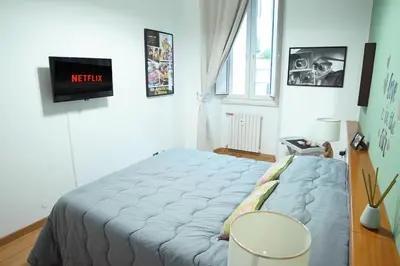 a bed in a room with a tv on the wall at FLOUR SUITE - Rome Apartment in Rome