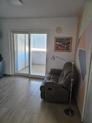 a living room with a couch and a clock on the wall at Two bedrooms with terrace in Rome