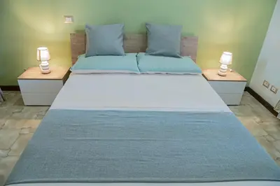 a large bed in a room with two lamps on tables at RHome City Garden in Rome