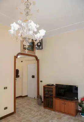 a living room with a chandelier and a television at RHome City Garden in Rome