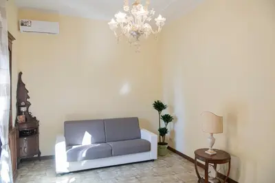 a living room with a couch and a chandelier at RHome City Garden in Rome