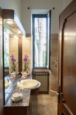 a bathroom with a sink and a large window at RHome City Garden in Rome
