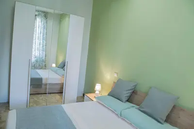 a bedroom with a bed and a large mirror at RHome City Garden in Rome
