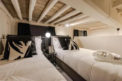 two beds in a room with black and white pillows at Acque Romane Fontana di Trevi M in Rome