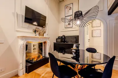 a dining room with a glass table and a fireplace at Acque Romane Fontana di Trevi M in Rome