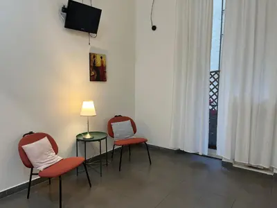 two chairs and a table with a lamp in a room at La casa di raffy in Rome