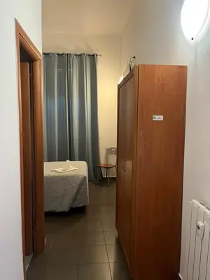 a room with a bed and a wooden cabinet at La casa di raffy in Rome