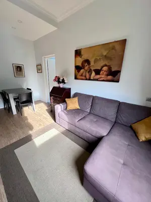 a living room with a purple couch and a table at Angelo ai Musei Vaticani bilocale in Rome