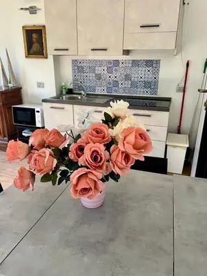 a vase filled with pink and white flowers in a kitchen at Angelo ai Musei Vaticani bilocale in Rome