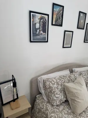 a room with a bed and a table with pictures on the wall at Mopy Apartment in Rome