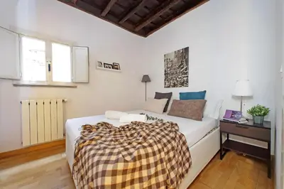 a white bedroom with a bed and a desk and a bed and a couch at Cozy Apartment Rione Monti in Rome