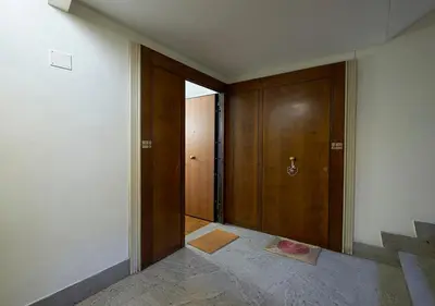 an empty hallway with a wooden door and stairs at Crimson Guest House in Rome