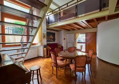a room with a table and chairs and a staircase at Crimson Guest House in Rome